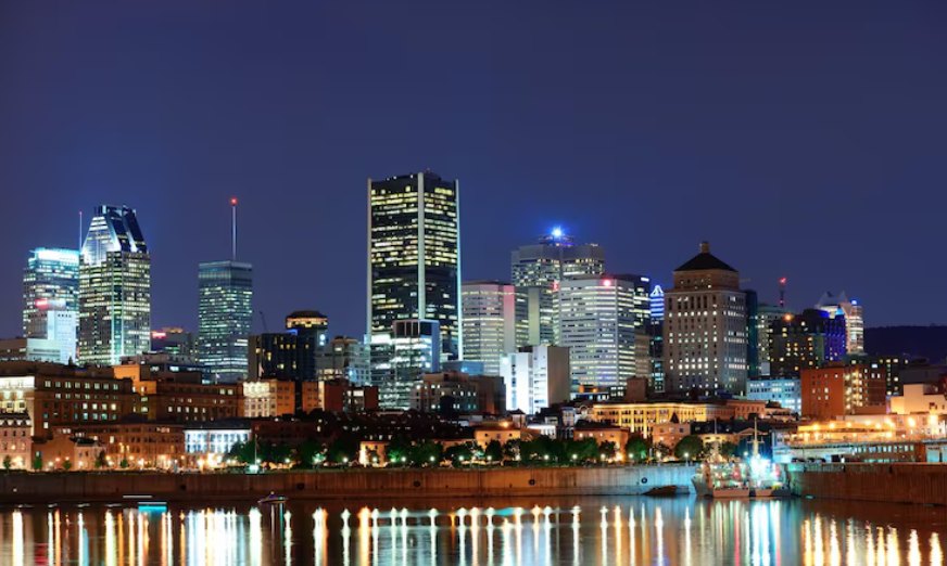 A city skyline lit at dusk beside the water